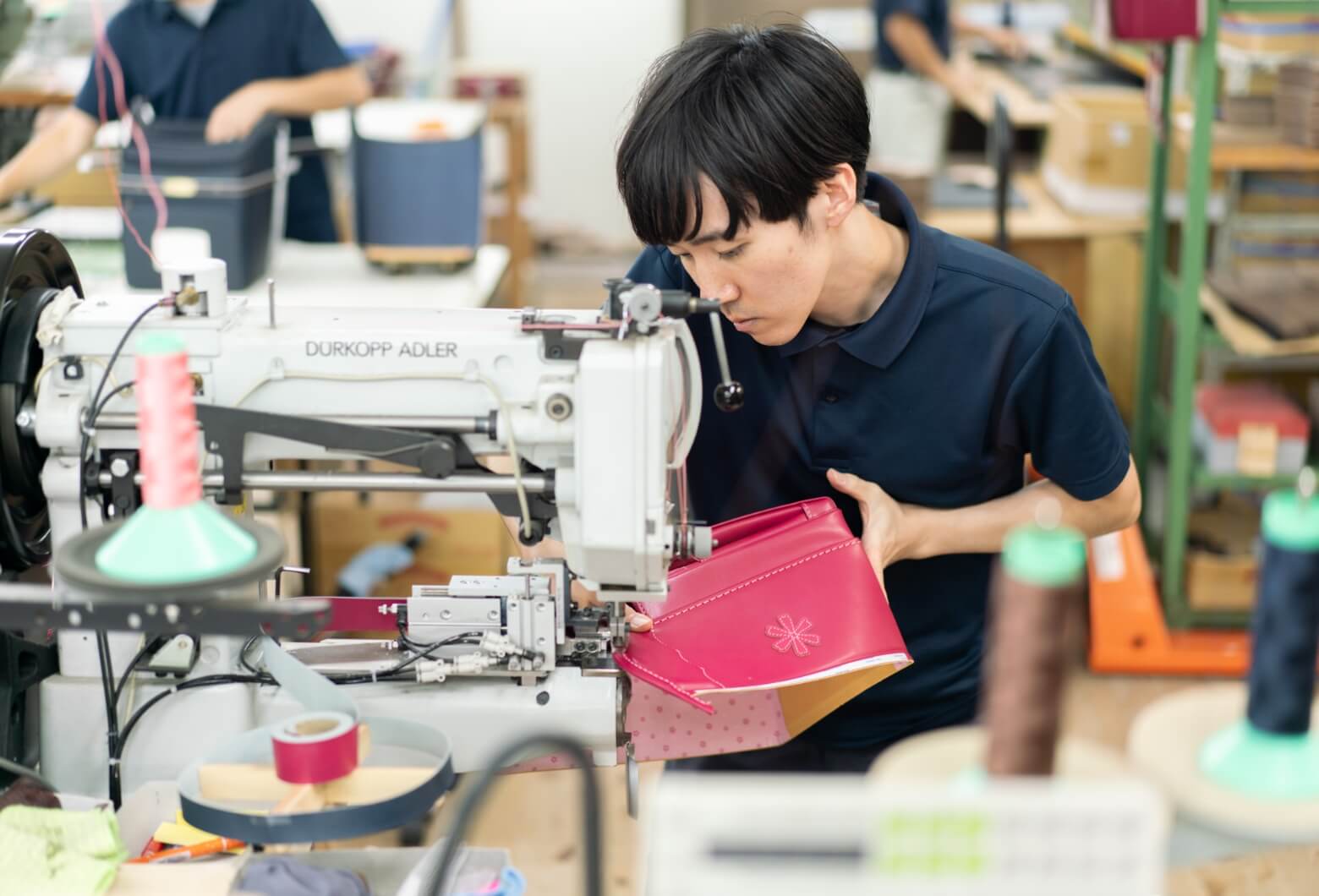 ミシンを使って作業を行う工房スタッフの写真