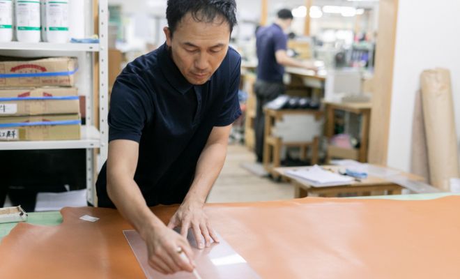 大きな革を確認する工房スタッフの写真