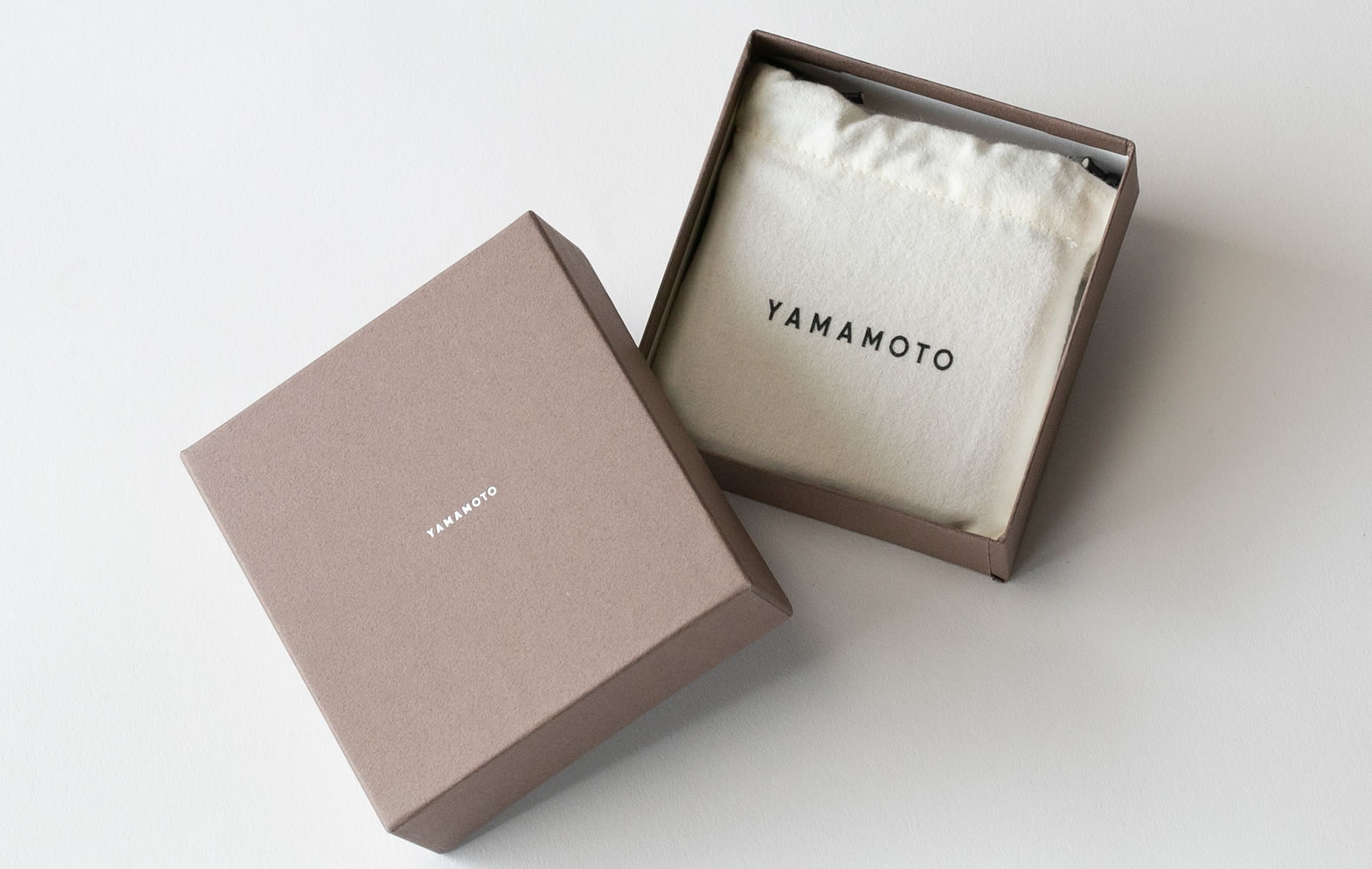 ブランド名であるYAMAMOTOのロゴが入った巾着とオリジナルボックス