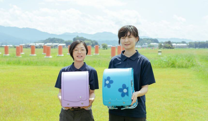 ランドセルを手に持った2人のスタッフの写真