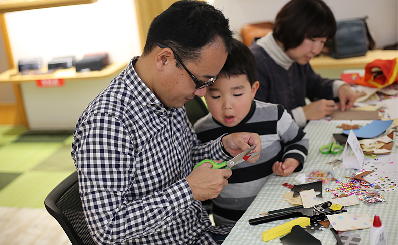 はさみで革を切るお父さまとお子さま