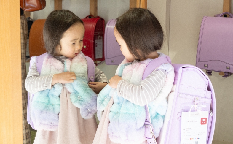 ラベンダー色のランドセルをフィッティングする女の子
