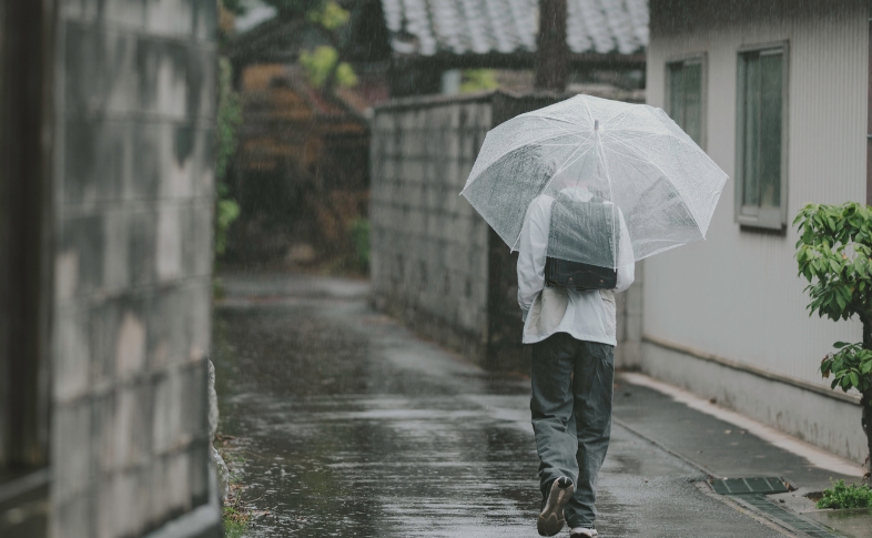 雨の通学路と、ランドセルを背負った少年