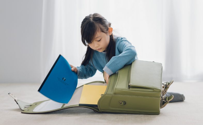 ランドセルにノートを入れる子ども