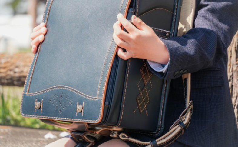 紺色のランドセルを持った子ども