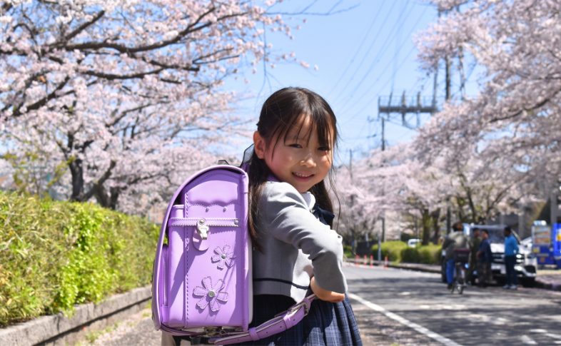 紫のランドセルを背負う子ども