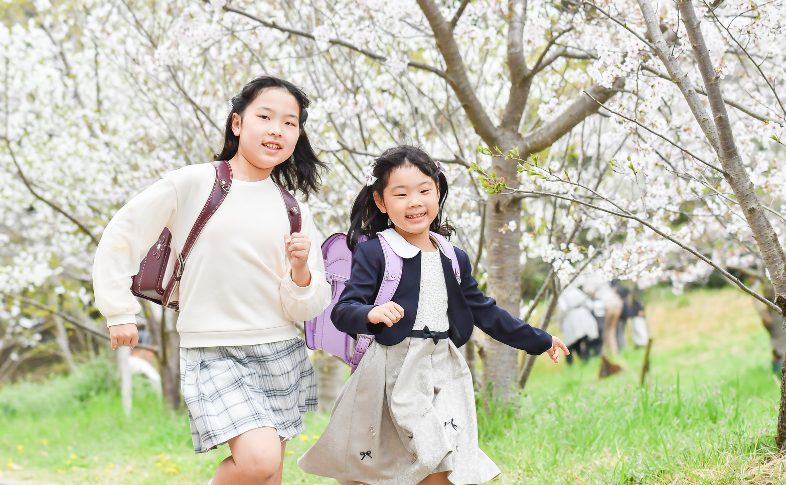 紫のランドセルを背負って走る子ども