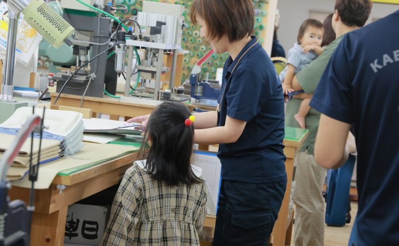ランドセルづくりを見る子ども