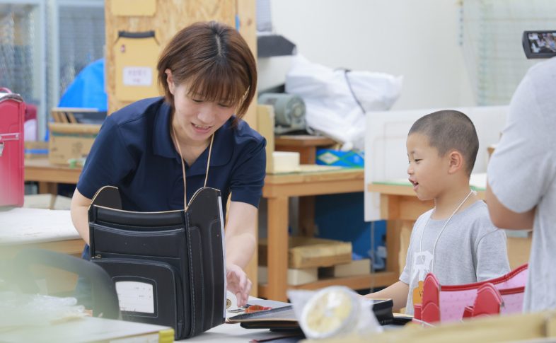 ランドセルづくりを見る子ども